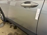 a silver car with a sticker on the side of it ' s door