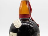 an old bottle of rum sitting on top of a white surface
