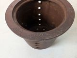 a small brown pot sitting on a white surface