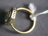 a gold ring with a green stone on top of it