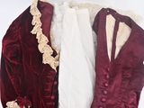 a red and white jacket and a white shirt on a stand