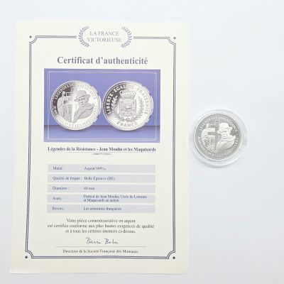 deux pièces d'argent et un certificat posés sur un fond blanc
