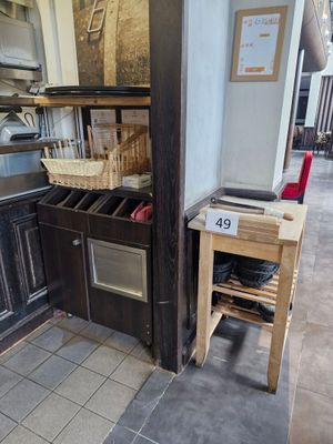 a kitchen with a stove, sink, oven, and cabinets