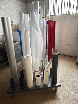 many rolls of white and red wrapping paper on a cart