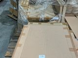 Plusieurs cartons sont empilés sur une palette dans un entrepôt