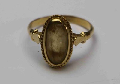 un gros plan d'une bague en or sertie d'une pierre
