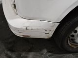 a close up of a white car with rust on it