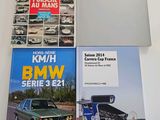 two books on a table with a car in the background