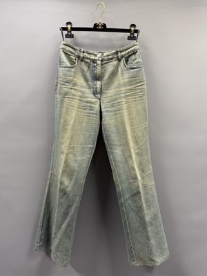 a pair of jeans hanging on a hanger against a wall