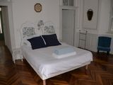 un lit blanc orné d'oreillers bleus, dans une chambre