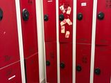 Plusieurs casiers rouges sont alignés en rang dans une pièce