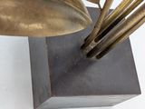 a metal sculpture of a flower on a wooden base