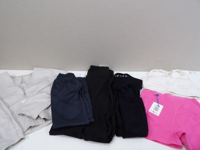 three pairs of black, pink, and white sweatpants laying on top of a bed