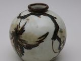 un vase blanc orné d'un motif représentant un oiseau noir