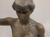 a statue of a boy holding a tennis racquet