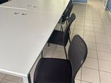 tables and chairs in a room with blue walls and white tile flooring
