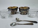 three silver and glass dishes and spoons on a white surface