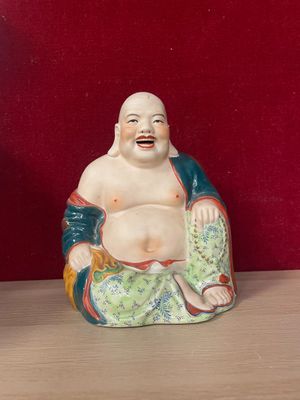 a statue of a laughing buddha sitting on a table
