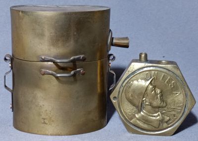 a gold container with a coin on it next to a metal container