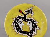 une assiette jaune ornée d'un motif en noir et blanc