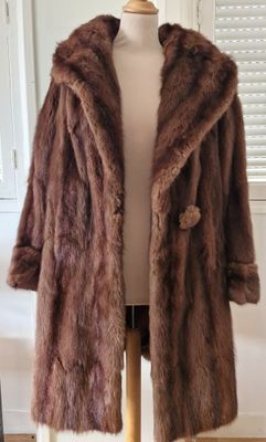 un manteau de fourrure marron posé sur un mannequin devant une vitrine