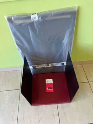 a red box with a black lid sitting on a tiled floor
