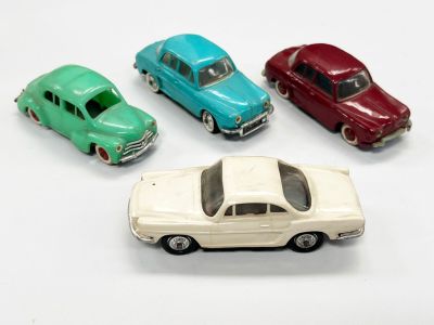 plusieurs petites voitures sont alignées sur une surface blanche