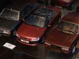 trois voitures exposées dans une vitrine
