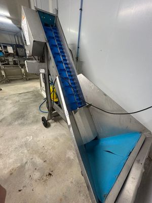 une image représentant un tapis roulant dans une usine, sur lequel est fixé un autre tapis roulant
