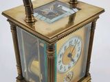 a gold clock that is sitting on a white surface