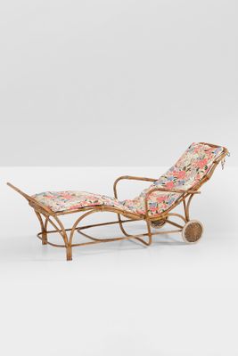 a pair of rattan loungers with floral cushions and wheels