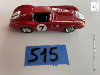une petite voiture rouge posée à côté d'une feuille de papier bleue