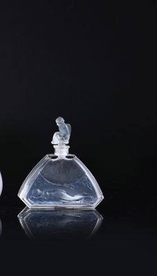 two small glass bottles sitting on top of a black surface
