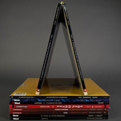 books stacked on top of each other with pencils on top
