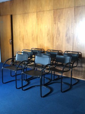 Plusieurs chaises sont alignées en rang dans une pièce vide.
