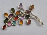 une photo d'une broche ornée de pierres multicolores