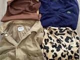 three pairs of shirts and pants are laid out on a wooden floor