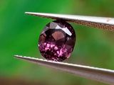 quelqu'un tient une paire de pinces ornées d'un diamant violet