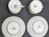 three white plates and two cups are sitting on a table