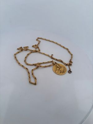 a close up of a gold chain with a coin on it