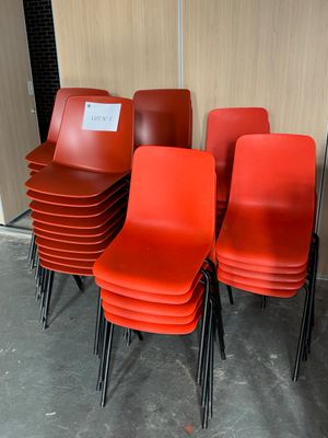 several red chairs are lined up against a wall in a room