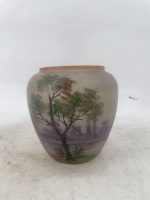 a vase with a painting on it sitting on a table