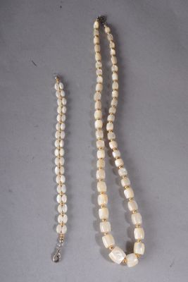 un collier de perles blanches avec un fermoir en argent et un collier de perles blanches avec un fermoir en argent