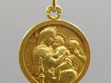 une image représentant une médaille d'or sur laquelle figure un homme tenant un enfant dans ses bras