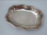 silver plate with scalloped edge on a white surface
