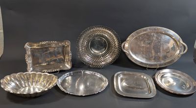 a lot of silver dishes and trays sitting on a table