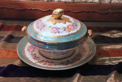 a blue and gold plate with a bird on top of it