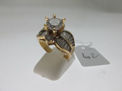une photo d'une bague en or sertie d'un diamant et de diamants taille baguette