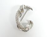 un gros plan d'une broche sertie de diamants sur un fond blanc