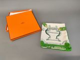 an orange box with a white and green napkin and a orange box with a white and green napkin